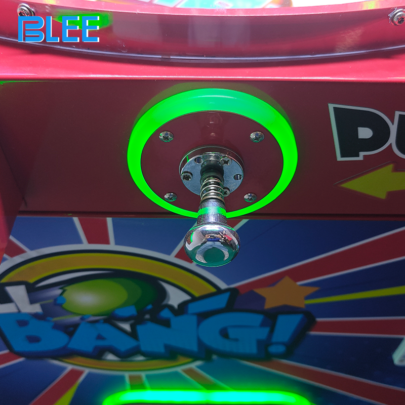 Close-up of the capsule dispensing chute where players retrieve their prize after turning the knob.