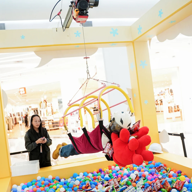 Young child laughing with joy while grabbing prizes during their human crane experience.