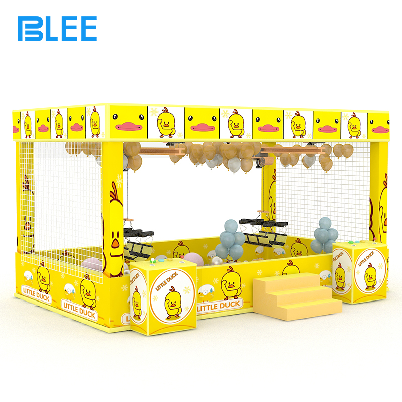 interactive arcade attraction Player inserting coins into the illuminated payment system to begin the human crane adventure.